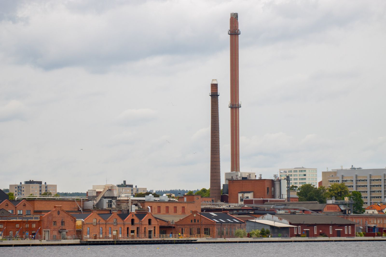 View of industrial chimneys and buildings by the river in Jönköping, Sweden.